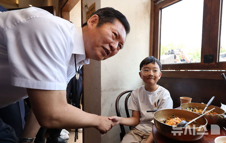 [경주=뉴시스] 이무열 기자 = 정청래 더불어민주당 대표가 20일 경북 경주시 황리단길 한 식당에서 어린이와 악수하고 있다. 2025.08.20. lmy@newsis.com