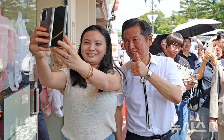 [경주=뉴시스] 이무열 기자 = 정청래 더불어민주당 대표가 20일 경북 경주시 황리단길을 찾아 시민과 기념촬영을 하고 있다. 2025.08.20. lmy@newsis.com