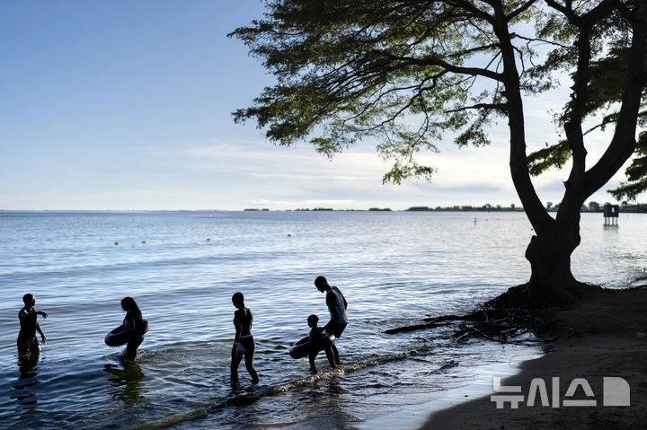 [AP/뉴시스] 우간다 자료사진으로 세계에서 두 번째로 큰 담수호수인 엔테베의 빅토리아호에 사람들이 걸어들어가고 있다&nbsp;&nbsp;&nbsp; 