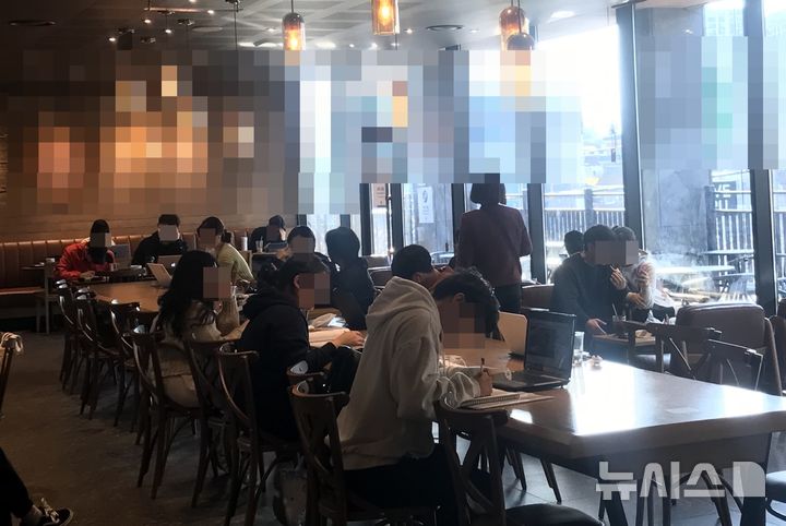 [서울=뉴시스] 24일 울산 중구의 한 프랜차이즈 카페 2층 매장에서 20~30대 학생과 직장인들이 다닥다닥 붙어 앉아 업무나 공부를 하고있다. (사진=구미현 기자) 2020.03.25.