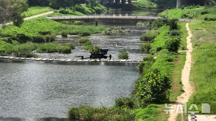 [안양=뉴시스] 최근 안양천 쌍개울에서 실시된 하천 드론 안내방송 비행 연습 현장. (사진=안양시 제공).2025.08.21.photo@newsis.com