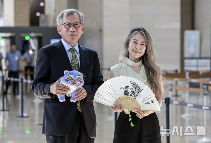 [서울=뉴시스] 정병혁 기자 = 유홍준 국립중앙박물관장과 넷플릭스 영화 '케이팝 데몬 헌터스'의 메기 강 감독이 21일 서울 용산구 국립중앙박물관에서 만나 인사를 나누며 선물을 들고 사진을 찍고 있다. 2025.08.21. jhope@newsis.com