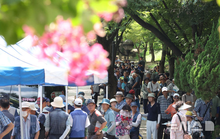 [대구=뉴시스] 이무열 기자 = 폭염이 연일 계속되고 있는 21일 대구 달서구 두류공원 사랑해밥차 무료 급식소에서 어르신들이 그늘에서 부채 등으로 더위를 식히며 점심 배식을 받기 위해 줄을 서고 있다. 2025.08.21. lmy@newsis.com
