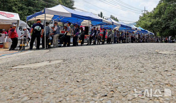 [대구=뉴시스] 이무열 기자 = 폭염이 연일 계속되고 있는 21일 대구 달서구 두류공원 사랑해밥차 무료 급식소에서 어르신들이 그늘에서 부채 등으로 더위를 식히며 점심 배식을 받기 위해 줄을 서고 있다. 2025.08.21. lmy@newsis.com