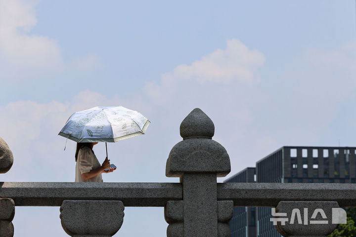 [서울=뉴시스] 권창회 기자 = 전국 대부분 지역에 폭염특보가 발효된 21일 서울 중구 청계천 인근에서 시민이 양산을 쓰고 이동하고 있다. 2025.08.21. kch0523@newsis.com