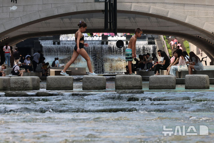 [서울=뉴시스] 권창회 기자 = 전국 대부분 지역에 폭염특보가 발효된 21일 서울 중구 청계천에서 외국인 어린이가 물놀이를 하고 있다. 2025.08.21. kch0523@newsis.com