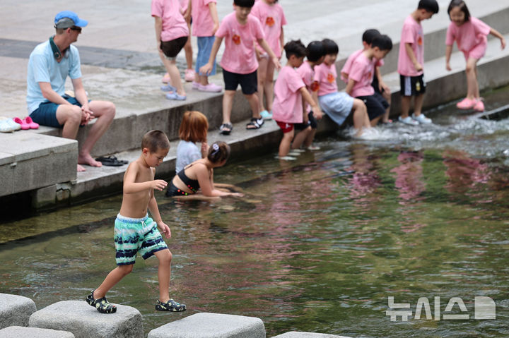 [서울=뉴시스] 권창회 기자 = 전국 대부분 지역에 폭염특보가 발효된 21일 서울 중구 청계천에서 외국인 어린이가 물놀이를 하고 있다. 2025.08.21. kch0523@newsis.com