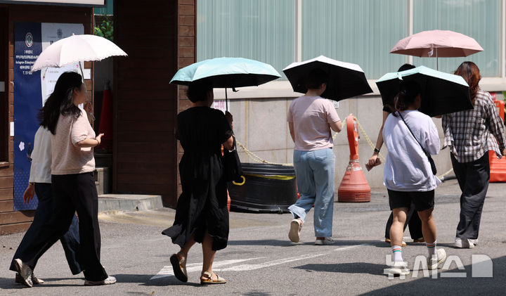 [서울=뉴시스] 권창회 기자 = 전국 대부분 지역에 폭염특보가 발효된 21일 서울 중구 청계천 인근에서 시민들이 양산을 쓰고 이동하고 있다. 2025.08.21. kch0523@newsis.com