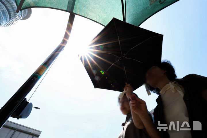 [서울=뉴시스] 권창회 기자 = 전국 대부분 지역에 폭염특보가 발효된 21일 서울 종로구 광화문광장 인근에서 시민들이 그늘막 아래서 햇빛을 피하며 신호를 기다리고 있다. 2025.08.21. kch0523@newsis.com