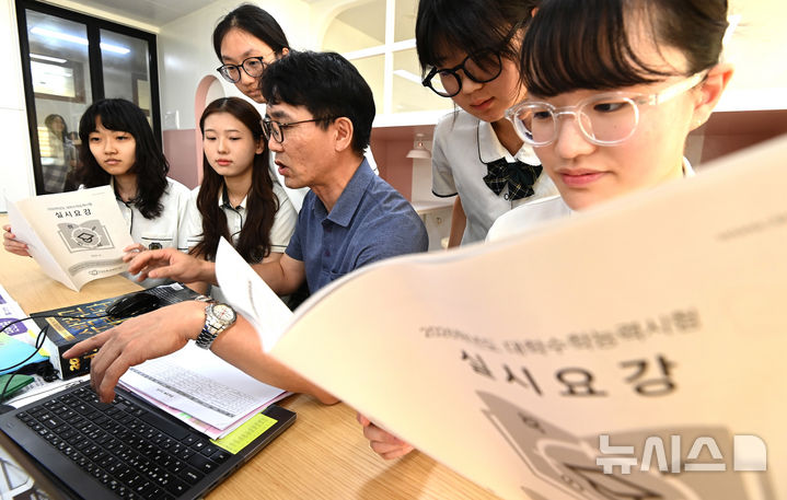 [수원=뉴시스] 김종택 기자 = 2026학년도 대학수학능력시험 응시원서 접수가 시작된 지난해 8월 21일 경기 수원시 영복여자고등학교에서 고3 수험생들이 선생님과 함께 수능 실시요강 등을 살펴보고 있다. 2025.08.21. jtk@newsis.com