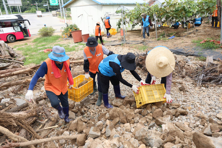 [안산=뉴시스]안산도시공사 임직원들이 수해현장에서 토사와 돌덩이들을 치우고 있다.(사진=안산도시공사 제공)2025.08.22.photo@newsis.com *재판매 및 DB 금지