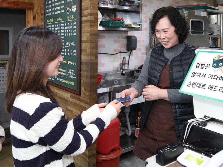 [무주=뉴시스] 전북 무주군은 지역화폐인 무주사랑상품권의 월 구매 한도액이 30만원 상향된다고 22일 밝혔다. 한 손님이 무주사랑상품권 가맹 식당에서 상품권을 통해 결제를 시도하고 있다. (사진=무주군 제공) 2025.08.22. photo@newsis.com *재판매 및 DB 금지