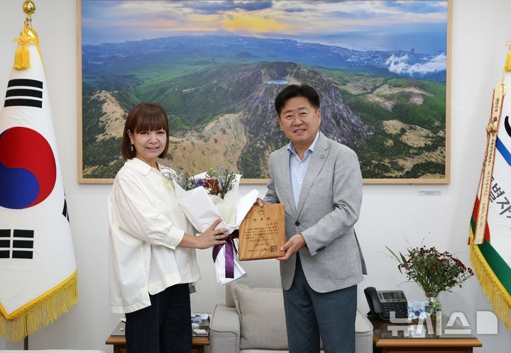 [제주=뉴시스] 오영훈 제주지사가 22일 오후 제주도청 집무실에서 원미연씨에게 제주도 홍보대사 위촉장을 수여한 후 함께 기념촬영하고 있다. (사진=제주도 제공) 2025.08.22. photo@newsis.com *재판매 및 DB 금지