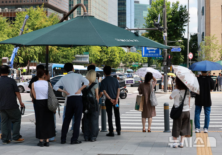 [서울=뉴시스] 이영환 기자 = 더위가 그친다는 절기상 처서를 하루 앞두고 찜통 더위가 이어지고 있는 22일 서울 종로구 광화문 네거리에서 양산을 쓴 시민들이 신호를 기다리고 있다. 2025.08.22. 20hwan@newsis.com
