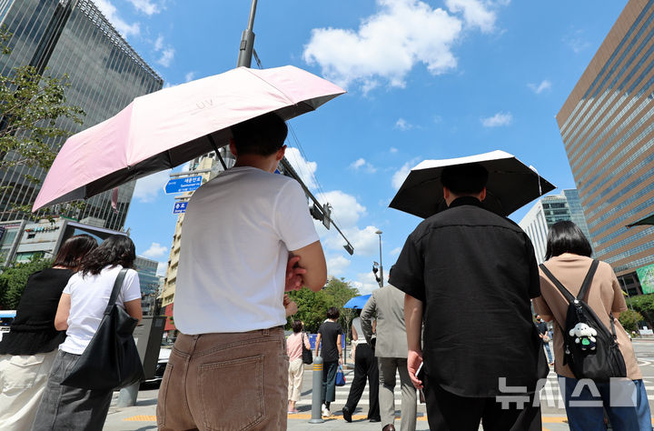 [서울=뉴시스] 이영환 기자 = 더위가 그친다는 절기상 처서를 하루 앞두고 찜통 더위가 이어지고 있는 22일 서울 종로구 광화문 네거리에서 양산을 쓴 시민들이 신호를 기다리고 있다. 2025.08.22. 20hwan@newsis.com