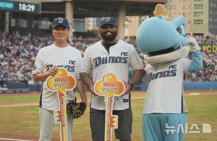 [창원=뉴시스]BNK경남은행 김태한(왼쪽) 은행장과 NC 다이노스 레전드 선수인 에릭 테임즈가 22일 저녁 롯데 자이언츠와 경기 전 시구·시타에 앞서 기념촬영하고 있다.(사진=BNK경남은행 제공) 2025.08.23. photo@newsis.com