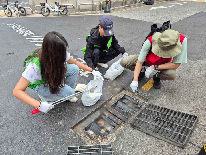 [서울=뉴시스] BBQ 대학생 봉사단 '올리버스'와 본사 직원들이 지난 23일 강남역 일대 빗물받이 청소 봉사활동을 진행했다.(사진=제너시스BBQ 제공) *재판매 및 DB 금지