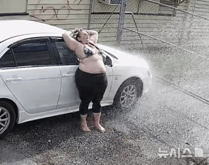 [뉴시스] 한 여성은 스프링클러 앞에서 물 맞는 것을 즐기고 있다.(사진=뉴욕포스트) 2025.08.24 