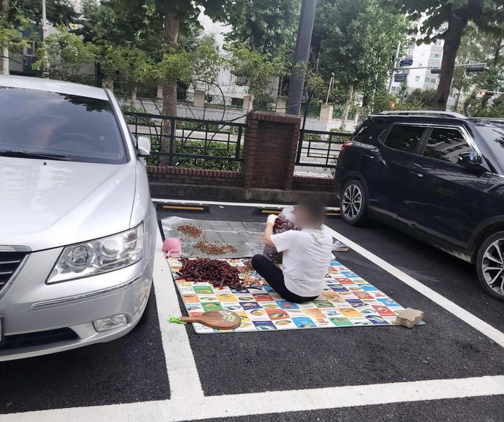 [뉴시스] 아파트 주차장서 고추 다듬는 중년 여성. (사진=보배드림) *재판매 및 DB 금지