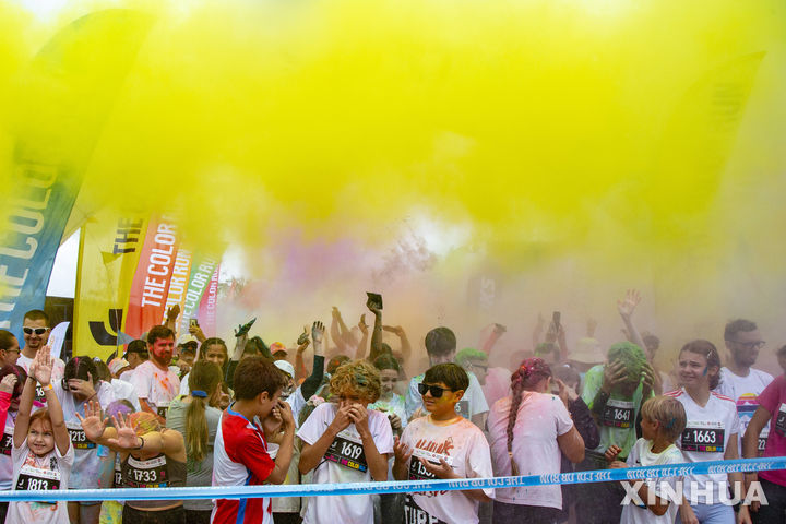 [유르말라=신화/뉴시스] 24일(현지 시간) 라트비아 유르말라에서 열린 '색채 달리기'(컬러런)에 참여한 참여자들이 색가루를 맞고 있다. 참가자들은 5㎞ 코스를 달리면서 색색의 가루와 거품이 쏟아지는 지점을 지나 다양한 색으로 물들게 된다. 2025.08.25.