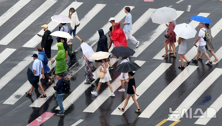 [서울=뉴시스] 추상철 기자 = 비가 내린 25일 오전 서울 종로구 광화문 앞에서 우산을 쓴 외국인 관광객이 횡단보도를 건너고 있다. 2025.08.25. scchoo@newsis.com