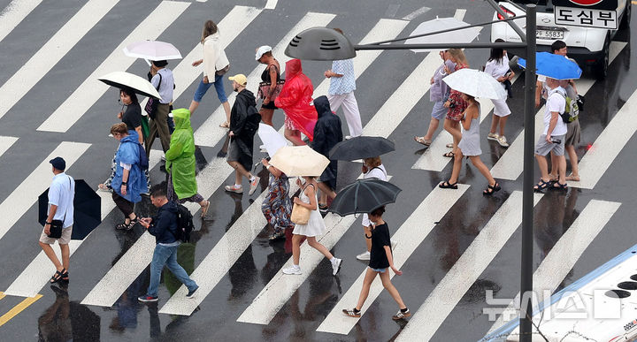 [서울=뉴시스] 추상철 기자 = 비가 내린 25일 오전 서울 종로구 광화문 앞에서 우산을 쓴 외국인 관광객이 횡단보도를 건너고 있다. 2025.08.25. scchoo@newsis.com