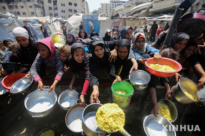 [가자시티=신화/뉴시스] 팔레스타인 피란민들이 24일(현지 시간) 가자지구 가자시티 남서부 난민촌에서 무료 음식을 받고 있다. 2025.08.25.