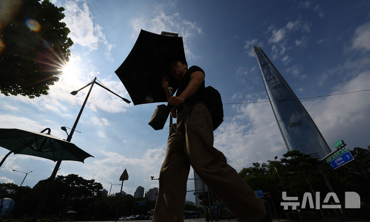 [서울=뉴시스] 황준선 기자 = 강남·서초·강동·송파구 등 서울 동남권에 폭염경보가 발효된 25일 오후 서울 송파구 석촌호수 사거리에서 양산을 쓴 시민들이 발걸음을 옮기고 있다. 2025.08.25. hwang@newsis.com