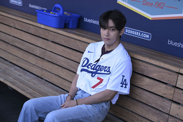 [로스앤젤레스=AP/뉴시스] 방탄소년단(BTS)의 뷔가 25일(현지 시간) 미 캘리포니아주 로스앤젤레스의 다저 스타디움 LA 다저스 더그아웃에 앉아 경기 시작을 기다리고 있다. 뷔는 이날 LA 다저스와 신시내티 레즈의 경기에 시구자로 나선다. 2025.08.26.