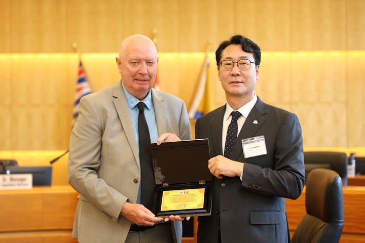 [화성=뉴시스]정명근 화성시장(사진 오른쪽)이 마이크 헐리 버나비 시장에게 자매도시 15주년을 기념해 감사패를 전달하고 기념촬영을 하고 있다.(사진=화성시 제공)2025.08.26.photo@newsis.com *재판매 및 DB 금지