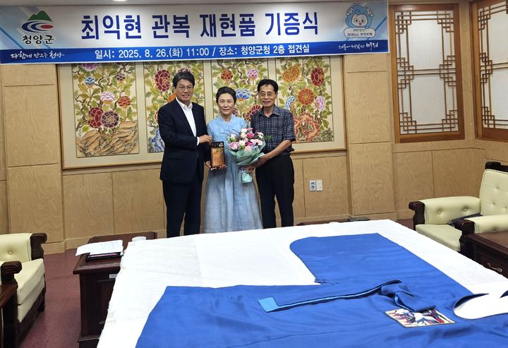 [청양=뉴시스] 조명휘 기자 = 김돈곤(왼쪽) 충남 청양군수가 26일 접견실에서 황길남(가운데) 서천침전장 전승교육자로부터 면암 최익현 선생 관복 재현품을 기증받고 있다. (사진= 청양군 제공) 2025.08.26. photo@newsis.com *재판매 및 DB 금지