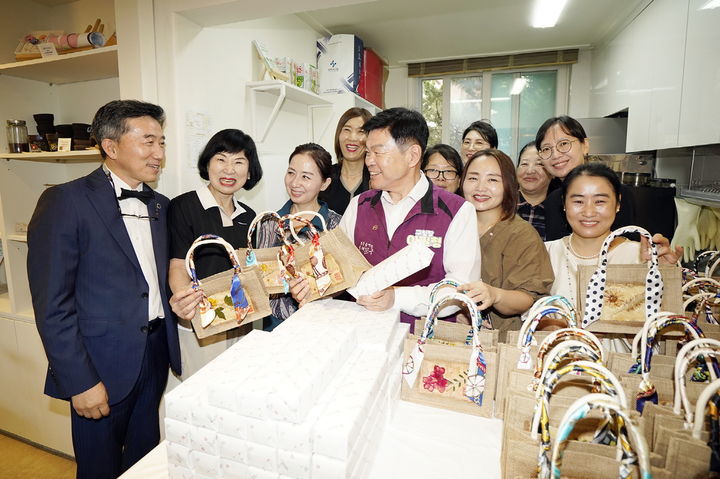 [서울=뉴시스] 자원순환 정거장 개소식 이필형동대문구청장(보라색 조끼)과 박주희 삼육보건대총장(사진 왼쪽 첫번째)이 재활용 우유팩 등으로 만들어진 가방을 보고 있다. 2025.08.26. (사진=동대문구 제공) *재판매 및 DB 금지