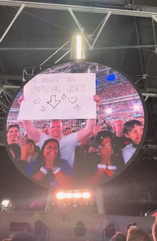 [뉴시스] 24일(현지시간) 미 매체 피플에 따르면 22일 런던 웸블리 스타디움에서 열린 콘서트에서 ‘청혼하고 싶다’라는 표지판을 들고 있는 한 남성이 키스캠에 등장했고, 그와 함께 그의 여자친구가 화살표 방향에 서서 환하게 웃고 있는 장면이 키스캠에 포착됐다. (사진=엑스 캡처 @Neil) *재판매 및 DB 금지