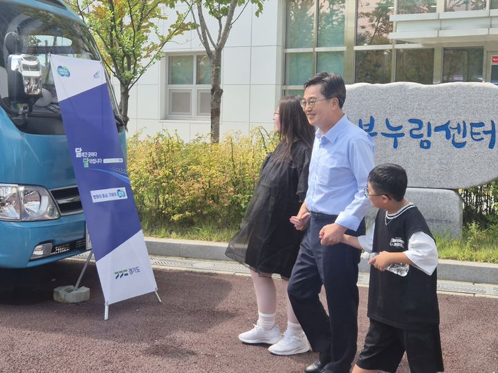 [양주=뉴시스] 이병희 기자 = 김동연 경기도지사가 26일 양주 북부장애인복지종합지원센터에서 장애 학생들의 손을 잡고 달달버스로 이동하고 있다. 2025.08.26. iambh@newsis.com *재판매 및 DB 금지