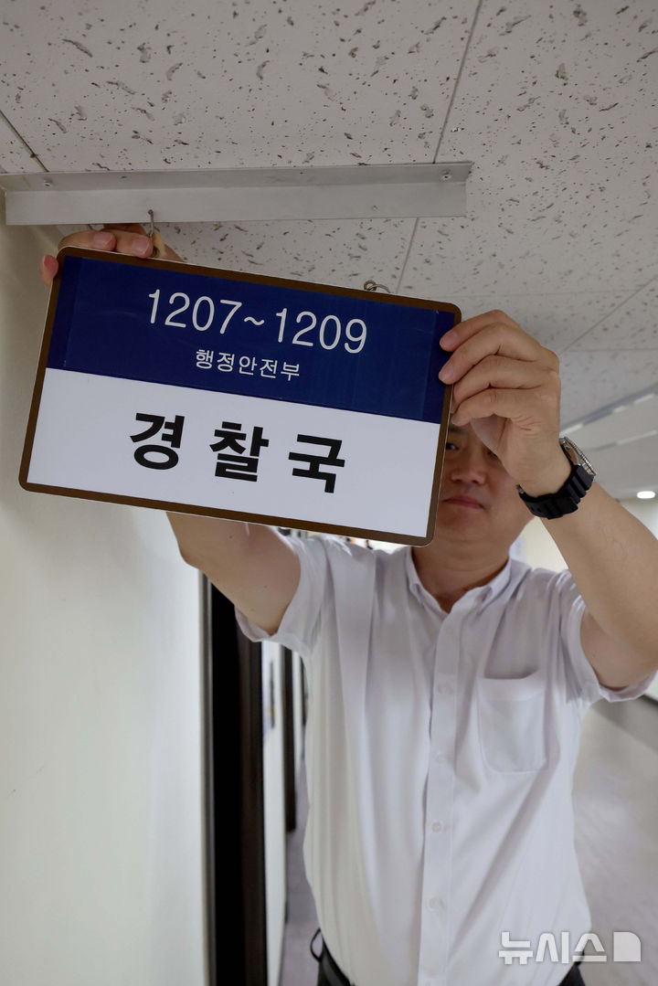 [서울=뉴시스] 추상철 기자 = 행정안전부가 대통령령인 ‘행정안전부와 그 소속기관 직제’를 시행해 경찰국이 폐지된 26일 서울 종로구 정부서울청사 내 경찰국 사무실에서 직원이 경찰국 간판을 제거하고 있다. (공동취재) 2025.08.26. photo@newsis.com