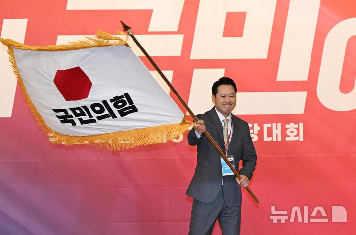 [서울=뉴시스] 국회사진기자단 = 장동혁 신임 국민의힘 대표가 26일 서울 여의도 국회도서관에서 열린 국민의힘 제6차 전당대회 결선에서 선출된 뒤 당기를 흔들고 있다. 2025.08.26. photo@newsis.com