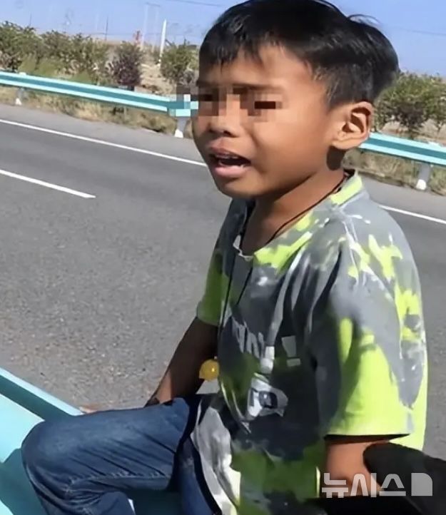 [뉴시스] 어린 남자아이가 아버지에 의해 중국 신장 자치구 국도에 홀로 버려져 울고 있는 모습.(사진=사우스차이나모닝포스트)