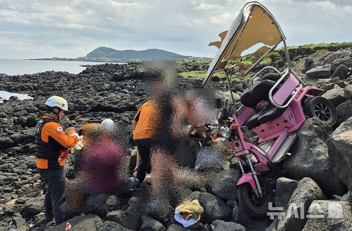 [제주=뉴시스] 27일오후 제주시 우도면 연평리 비양도에서 60대 남여 2명이 탄 삼륜전기스쿠터가 바닷가로 추락했다. 이 사고로 탑승자 2명이 다쳐 출동한 소방대원이 응급처치 등 구조활동에 나서고 있다. (사진=제주도소방안전본부 제공) 2025.08.27. photo@newsis.com *재판매 및 DB 금지