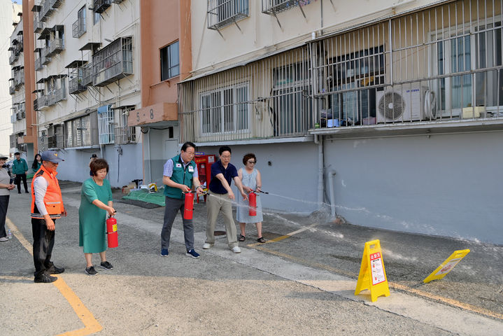 [부산=뉴시스] 부산 동구는 화재 취약지역 19곳에 소화기, 방열 장갑 등으로 구성된 소화 장비 보관함을 설치했다. 사진은 김진홍 동구청장이 소화기를 사용하는 모습. (사진=부산 동구 제공) 2024.08.27. photo@newsis.com *재판매 및 DB 금지
