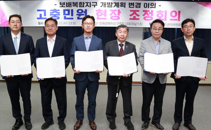 [창원=뉴시스] 강경국 기자 = 27일 부산·진해경제자유구역청 대회의실에서 경남 창원시 진해구 보배복합지구 개발계획 민원 해소를 위한 국민권익위원회 현장 조정회의가 열린 가운데 참석자들이 합의문을 들고 기념촬영을 하고 있다. (사진=부산·진해경제자유구역청 제공). 2025.08.. photo@newsis.com *재판매 및 DB 금지