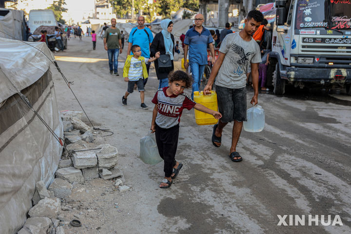 [가자시티=신화/뉴시스] 1일(현지 시간) AP통신에 따르면 데이비드 라미 영국 외무장관은 의회 보고에서 가자와 인근 지역에 1500만 파운드 규모의 추가 의료 지원을 제공한다고 밝혔다. 사진은 지난달 25일(현지 시간) 팔레스타인 난민들이 가자지구 가자시티 난민촌 급수차에서 물을 받아 나르고 있다. 2025.09.02.