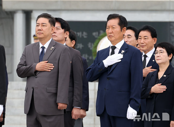 [대전=뉴시스] 김명년 기자 = 정청래(오른쪽) 더불어민주당 대표가 27일 오전 대전 유성구 국립대전현충원에서 김병기 원내대표 등 의원들과 함께 현충탑 참배를 마친 뒤 국민의례하고 있다. 2025.08.27. kmn@newsis.com