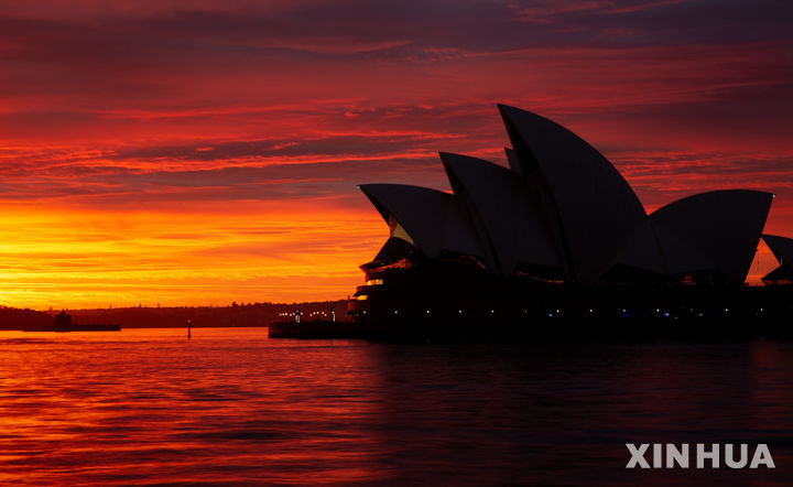 [시드니=신화/뉴시스] 27일(현지 시간) 호주 시드니에 있는 오페라하우스가 아침노을과 함께 모습을 드러내고 있다. 2025.08.27.