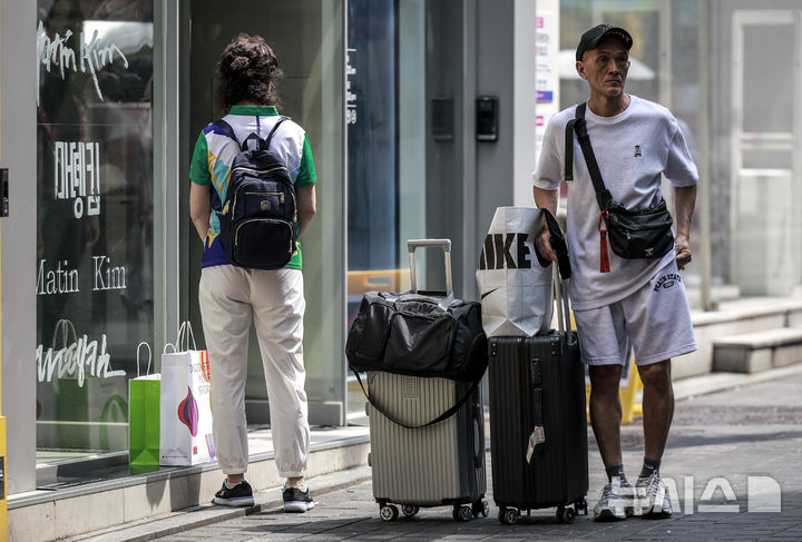 [서울=뉴시스] 정병혁 기자 = 27일 서울 중구 명동거리를 찾은 외국인 여행객들이 쇼핑백을 들고 이동하고 있다. 2025.08.27. jhope@newsis.com