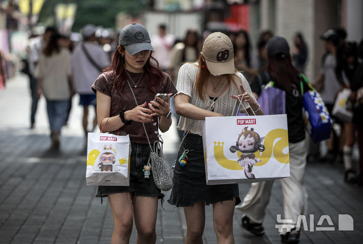 [서울=뉴시스] 정병혁 기자 = 서울 중구 명동거리를 찾은 외국인 여행객들이 쇼핑백을 들고 이동하고 있다. 2025.08.27. jhope@newsis.com