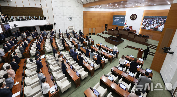 [서울=뉴시스] 김선웅 기자 = 27일 서울 중구 서울특별시의회에서 제332회 임시회 개회식이 열려 서울시의원들이 국기에 대한 경례를 하고 있다. 2025.08.27. mangusta@newsis.com