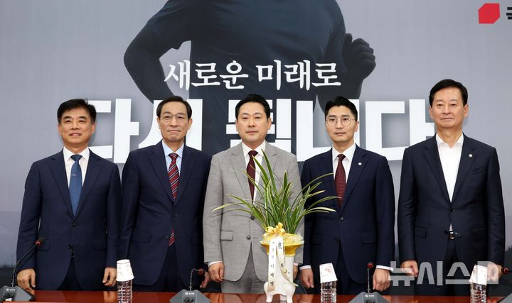 [서울=뉴시스] 조성봉 기자 = 장동혁 국민의힘 대표가 27일 오후 서울 여의도 국회에서 우상호 대통령비서실 정무수석에게 이재명 대통령 명의의 축하 난을 선물받고 기념촬영을 하고 있다. 2025.08.27. suncho21@newsis.com