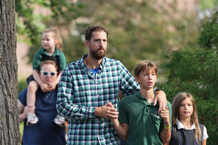 [미니애폴리스=AP/뉴시스] 지난해 8월 27일 미 미네소타주 미니애폴리스의 아나운시에이션 가톨릭 학교에서 총기 난사가 발생한 후 한 남성이 아들을 진정시키고 있다. 현지 경찰은 무장 괴한이 등교 시간에 총기를 난사해 어린이 2명이 숨지고 17명이 부상했다고 밝혔다. 20대 초반의 용의자는 현장에서 스스로 목숨을 끊었다. 2025.08.28.