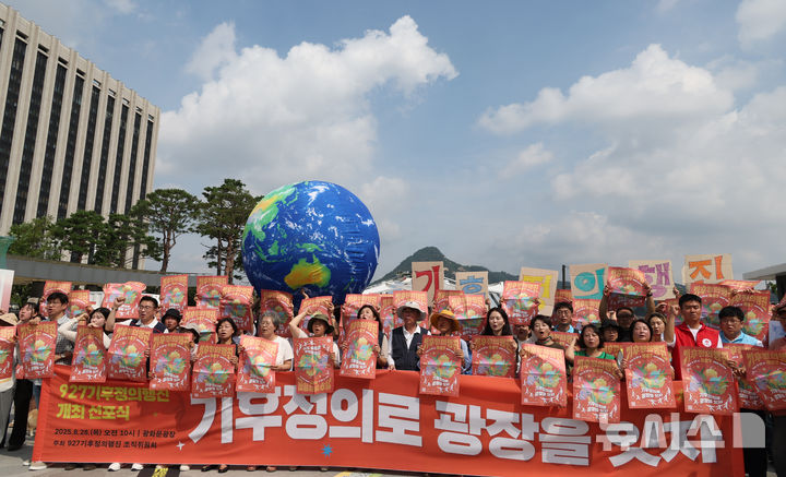 [서울=뉴시스] 김명원 기자 = 927 기후정의행진 참석자들이 28일 오전 서울 종로구 광화문 광장 북측(세종대왕 동상 뒤)에서 927 기후정의행진 선포식 기자회견을 마친후 포스터 퍼포먼스를 하고 있다. 2025.08.28. kmx1105@newsis.com
