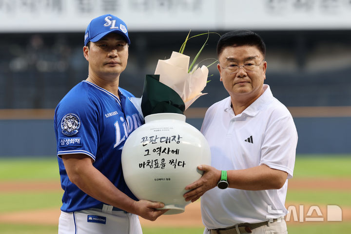 [서울=뉴시스] 권창회 기자 = 28일 서울 송파구 잠실야구장에서 KBO리그 두산 베어스와 삼성라이온즈의 경기 시작에 앞서 열린 오승환 은퇴투어 기념행사에서 삼성 오승환이 김태룡 두산베어스 단장으로부터 달항아리를 전달받고 있다. 2025.08.28. kch0523@newsis.com